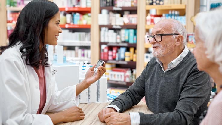 An older adult talks about blood sugar testing with the pharmacist.