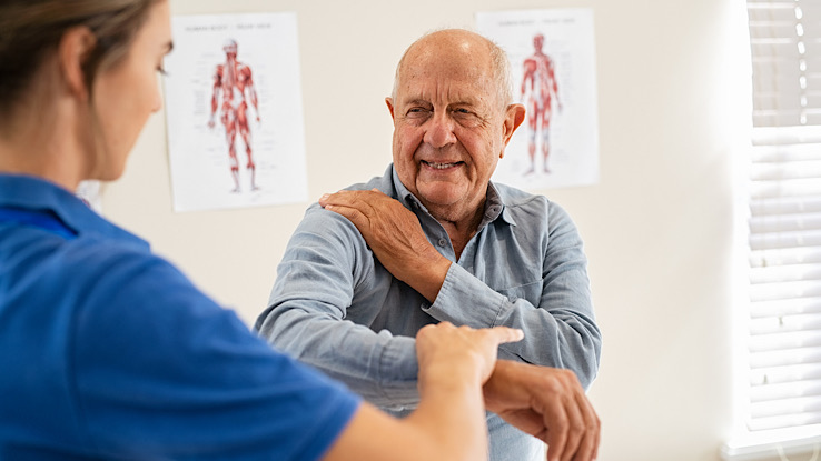 Older adult is sharing shingles symptoms with the doctor.