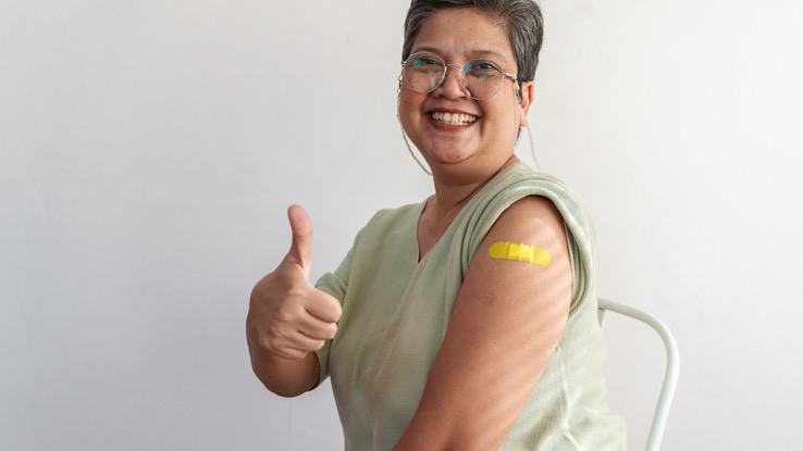 Older adult gives a thumbs up after shingles vaccine.
